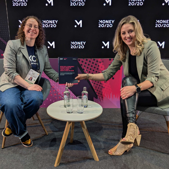 A picture of a representative from FXC Intelligence and one from Money 20/20 holding the report