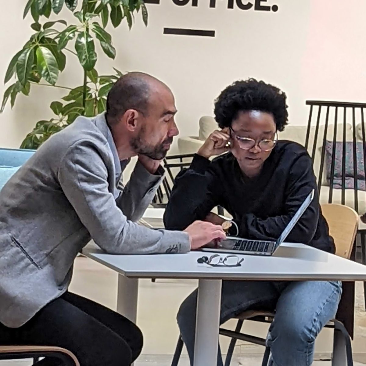 Two FXC Intelligence employees look at a laptop